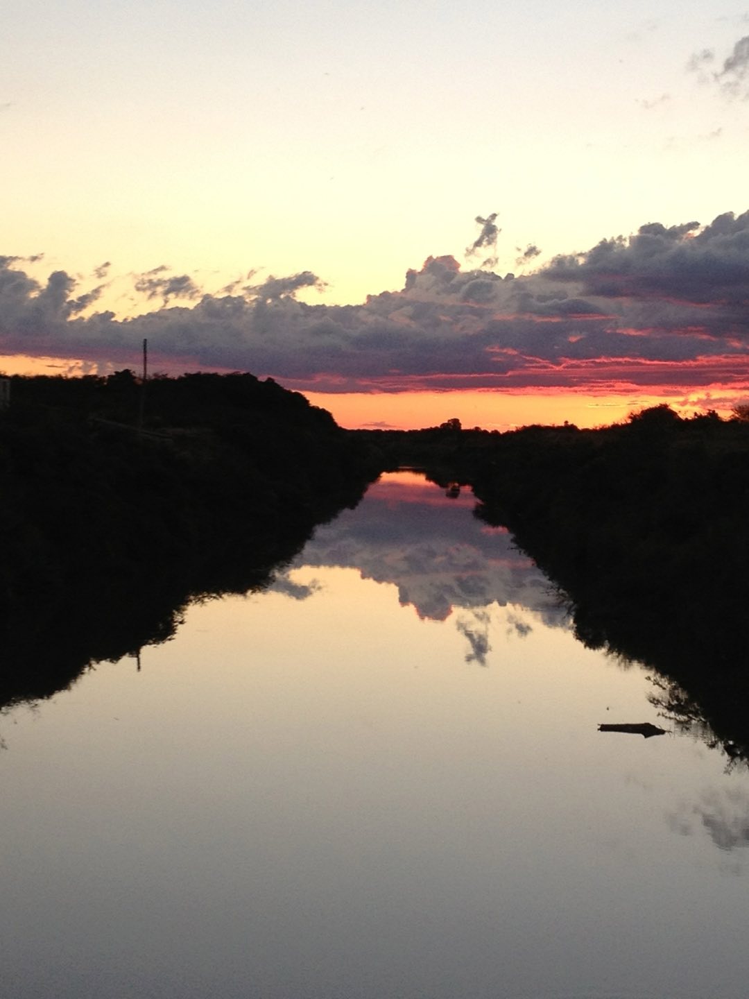 Pôr do sol alaranjado sobre a água, na orla de Arambaré