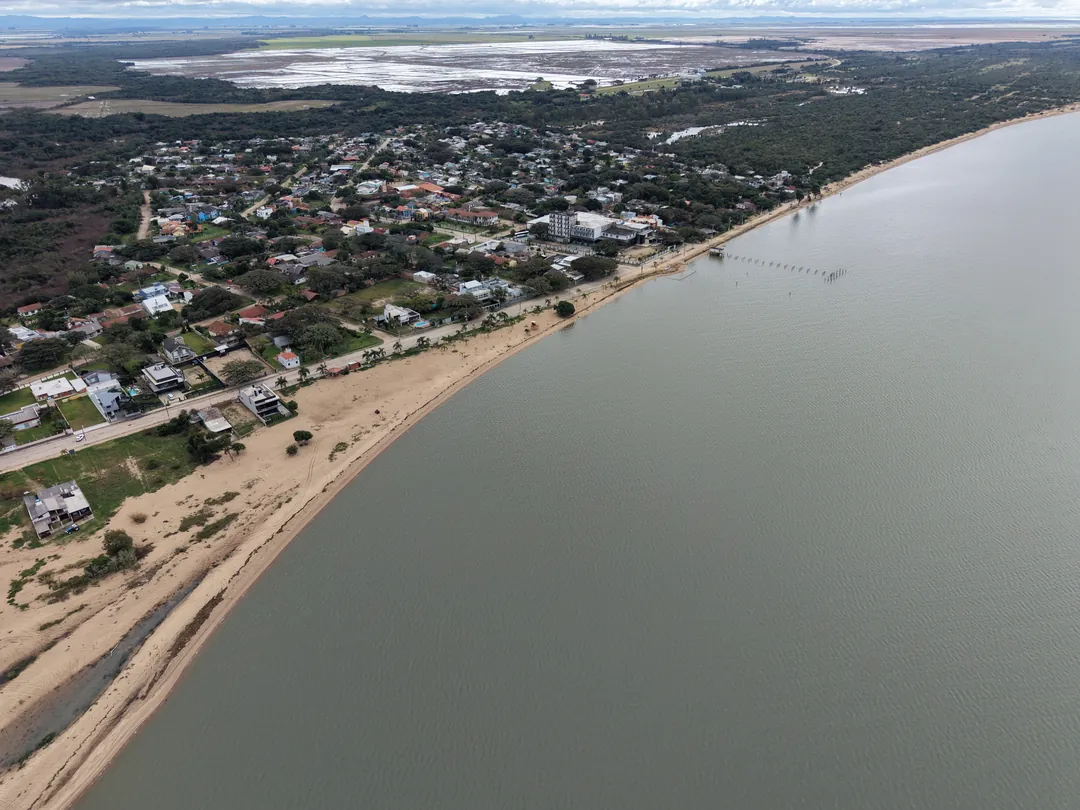 Faixa de areia clara contornando a orla da Lagoa dos Patos, em Arambaré